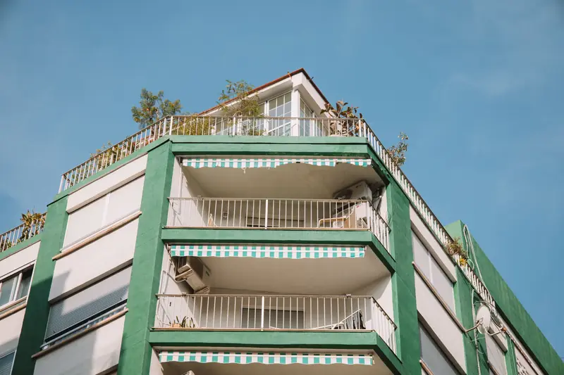 Bloque de pisos con balcones y toldos a rayas